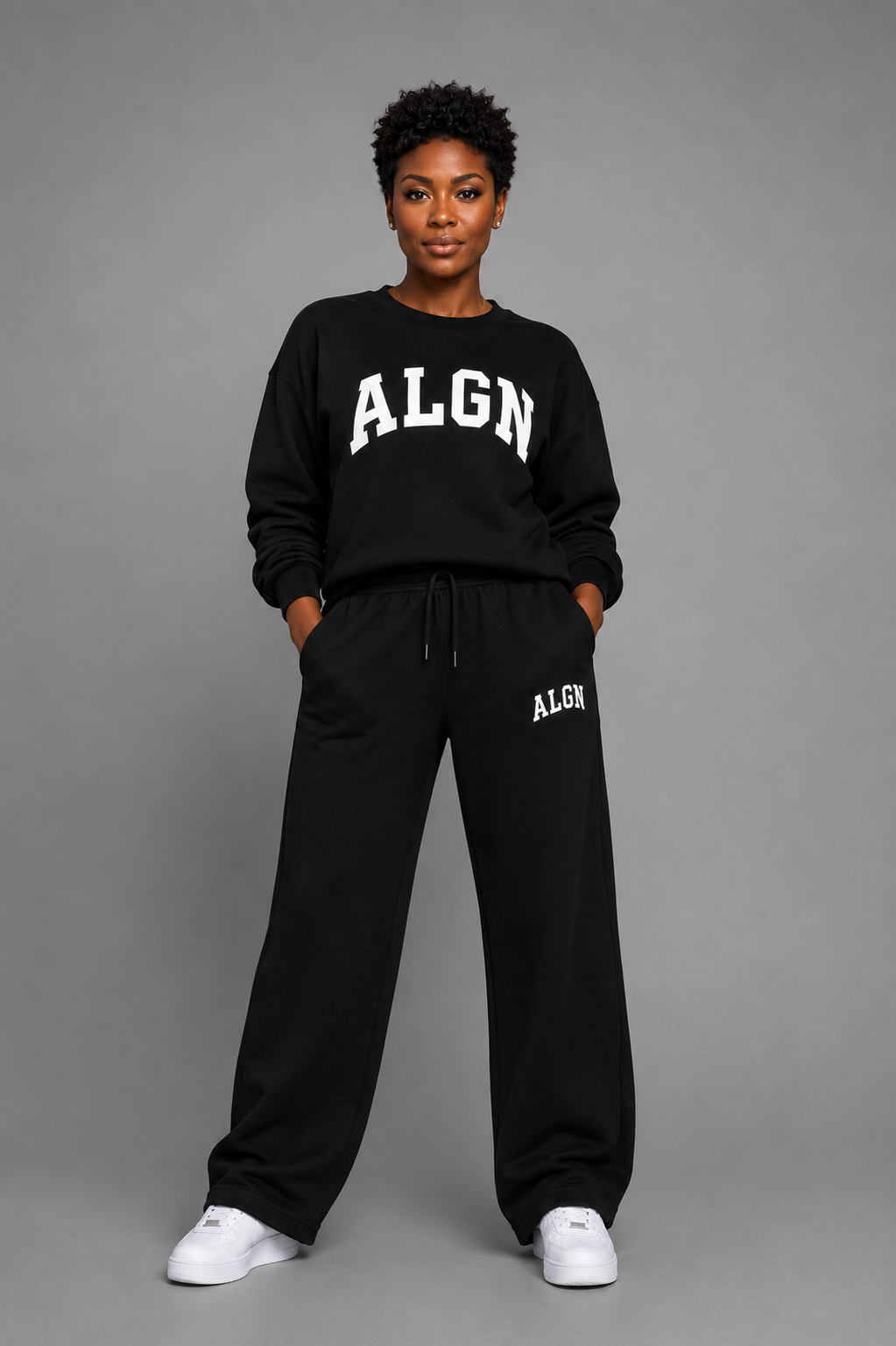 Model wearing the black ALGN collegiate loose-fit set with white lettering